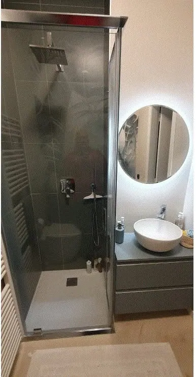 Bagno con doccia e specchio tondo