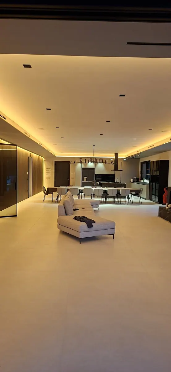 Villa: zona giorno lunga illuminata da luce calda