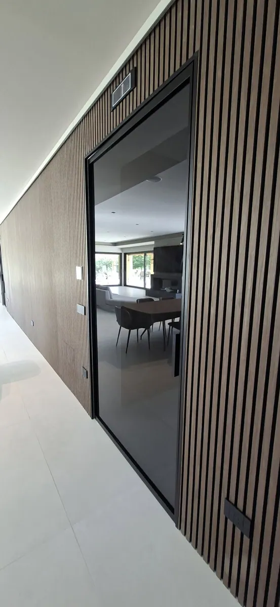 Villa: parete in legno cannettato e porta in vetro