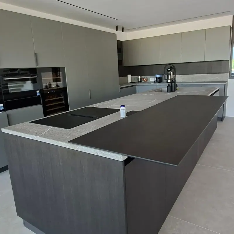 Cucina con isola scura e piano in pietra
