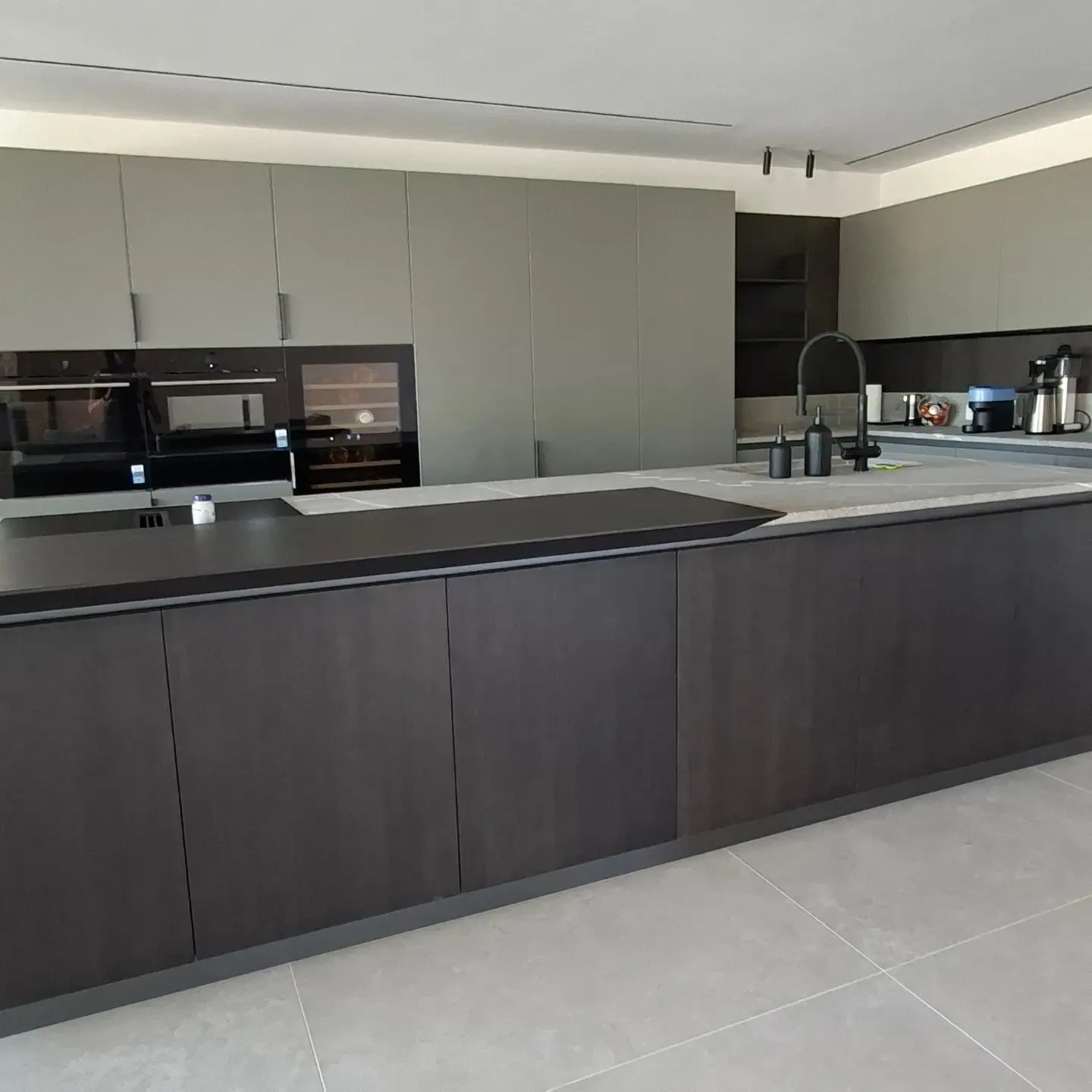 Cucina con isola scura e colonne grigie, vista frontale